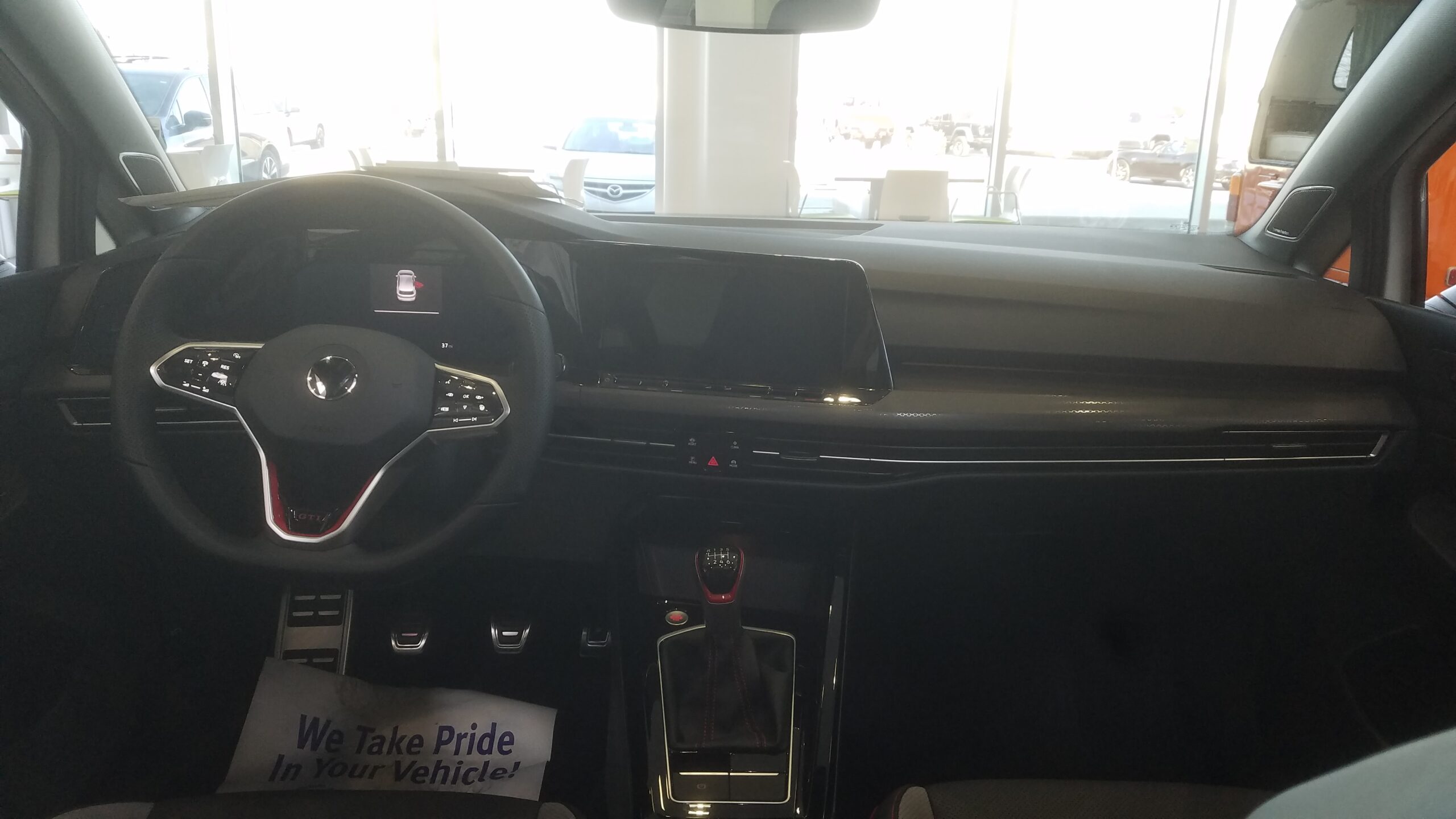 Interior dashboard of a 2023 Volkswagen Golf GTI showing the steering wheel and infotainment display.