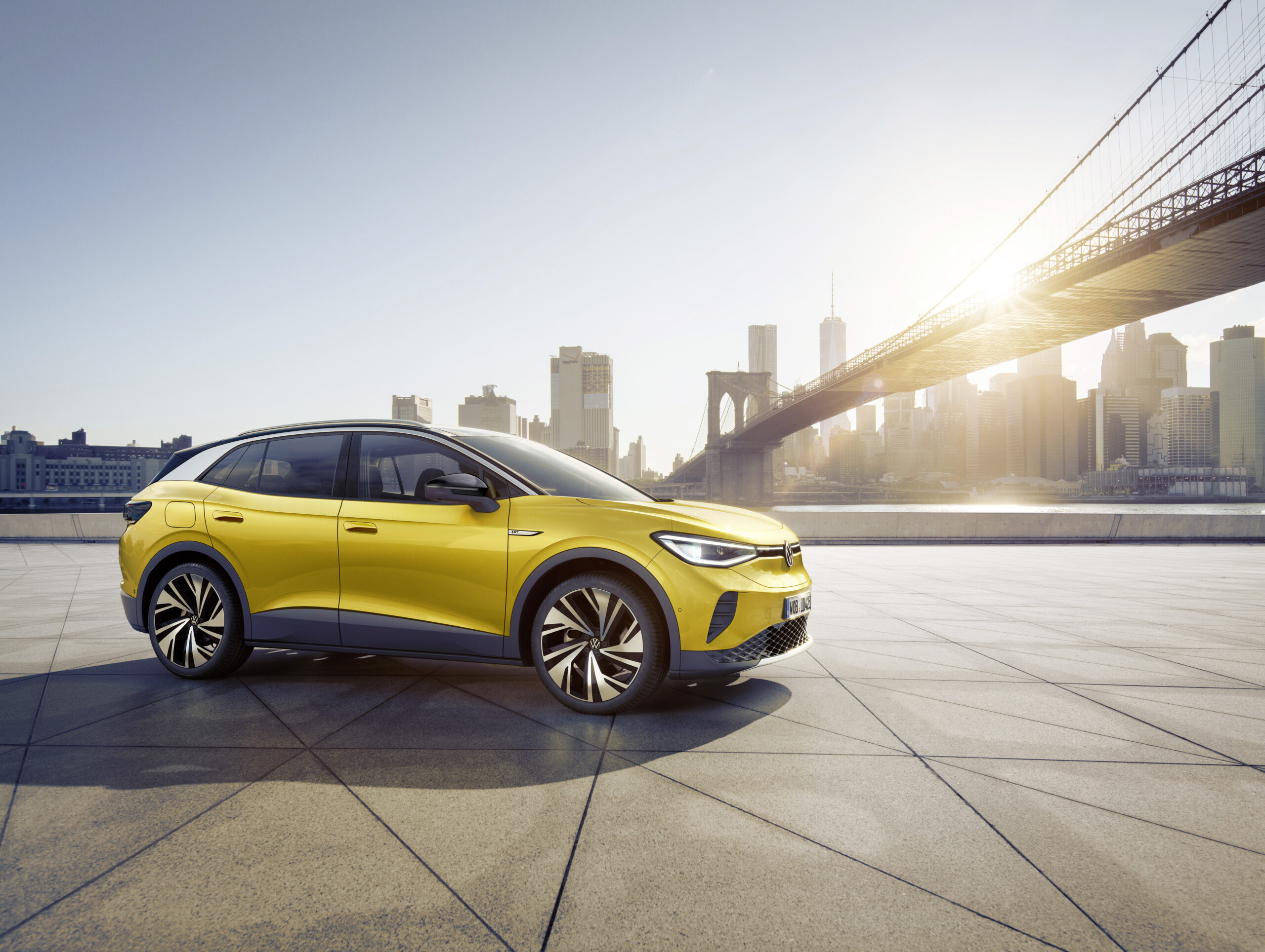 Yellow Volkswagen ID.4 1ST Max electric SUV parked in an open urban setting.