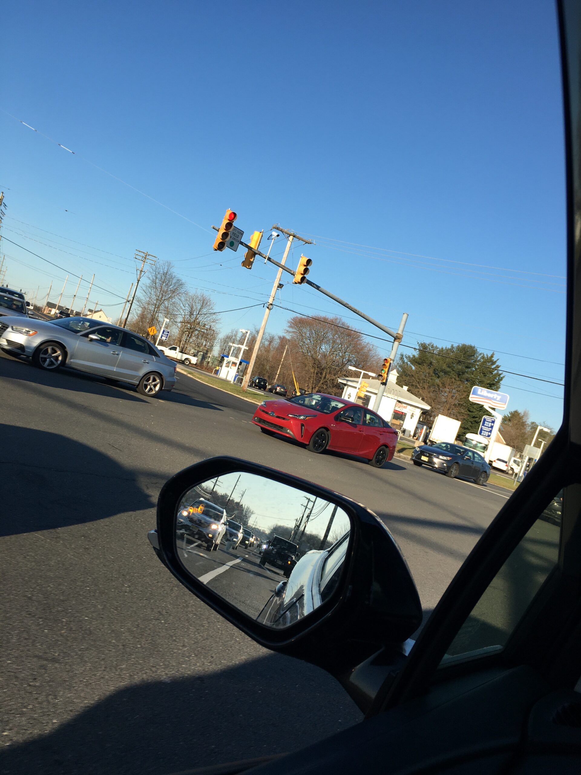 Driver-assist features shown through an active blind-spot warning in a car side mirror.