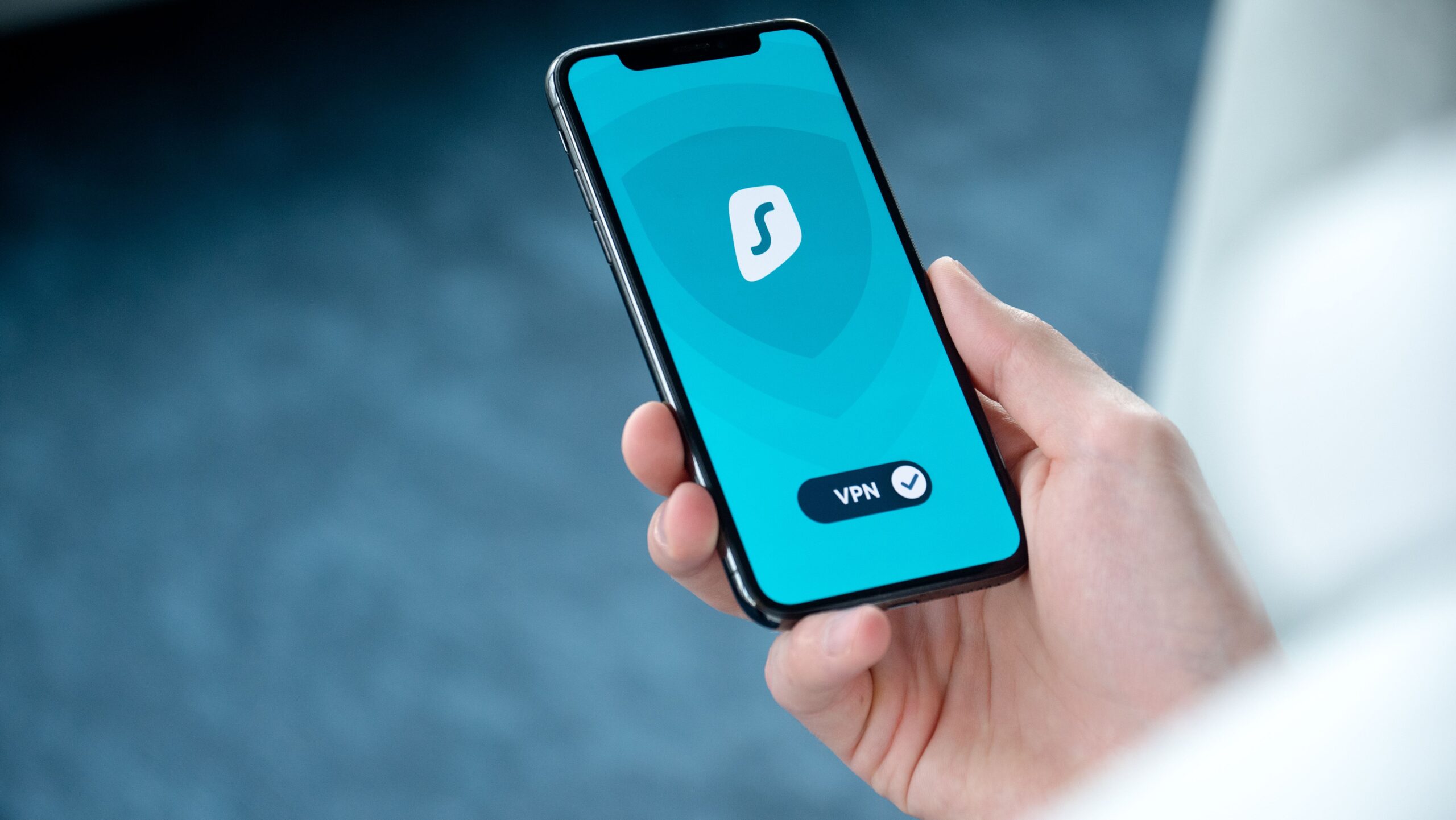 Person holding a smartphone with a security app screen during a suspicious link safety check.