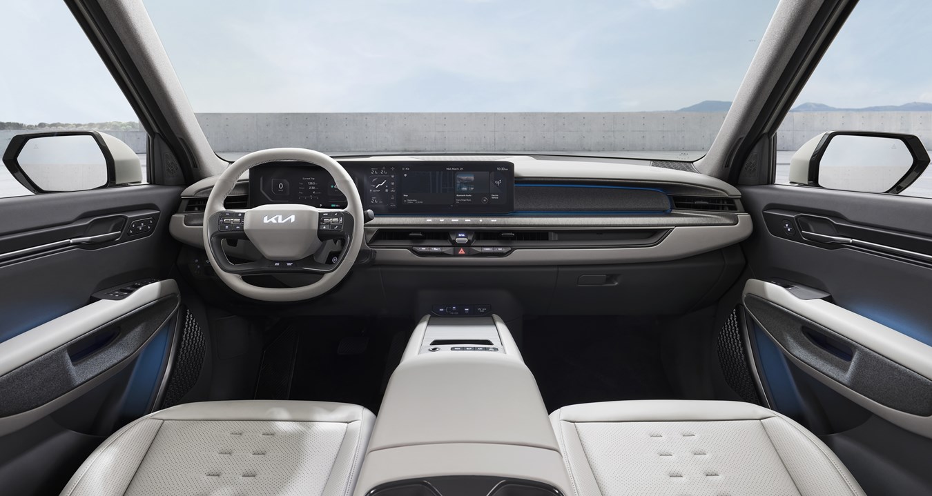 Kia EV9 interior with steering wheel, dashboard, and central infotainment display.